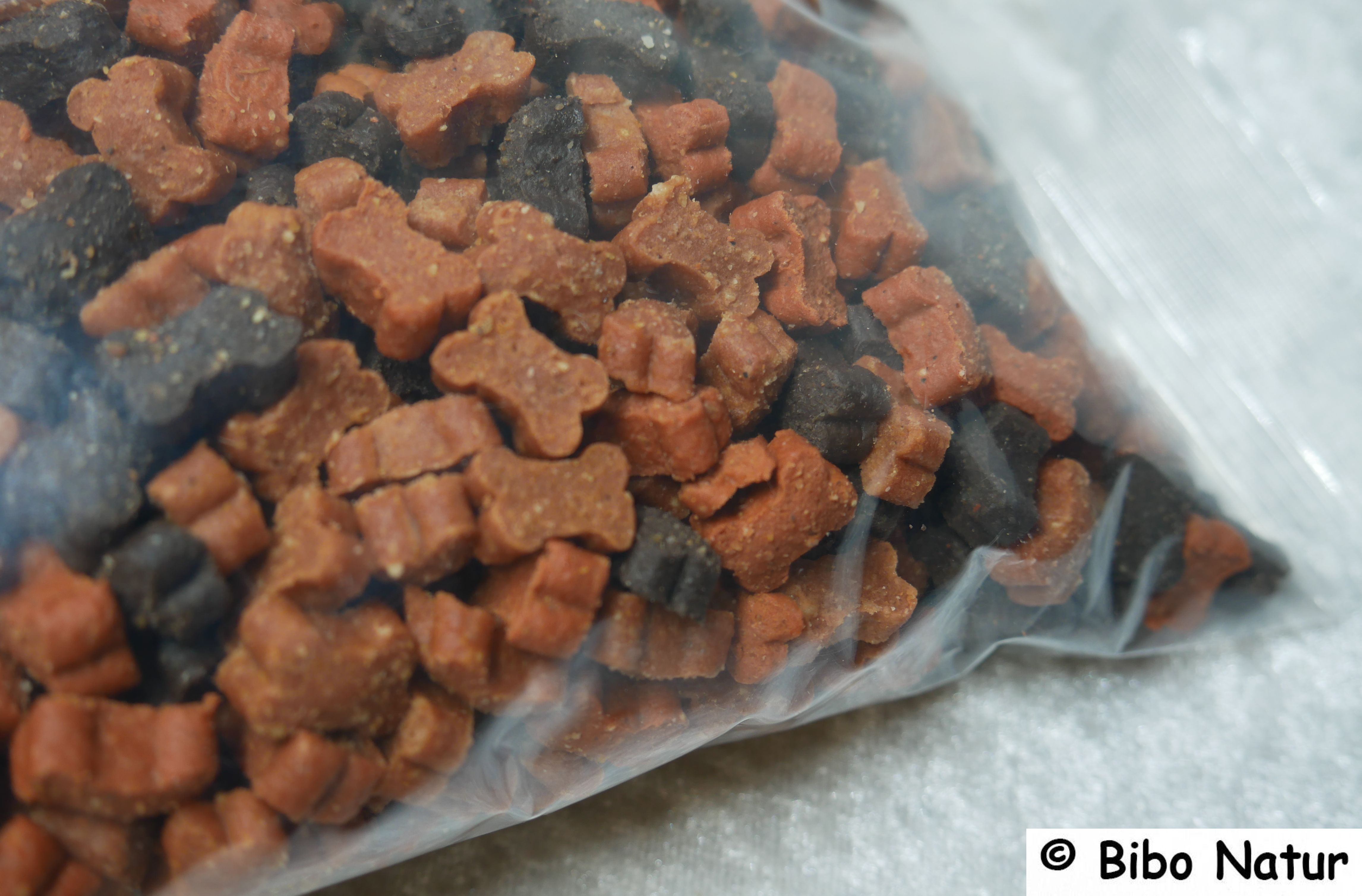 Nahansicht dunkelbraune und orange Leckerlies in Hundeknochenform